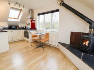 a kitchen with a fireplace and a table and a stove at Tyn-y-Mynydd Bach in Halkyn