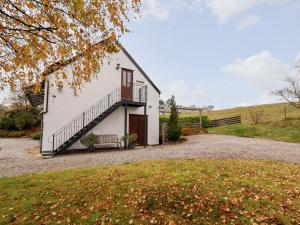 ein weißes Haus mit einer Treppe neben einem Hof in der Unterkunft Tyn-y-Mynydd Bach in Halkyn