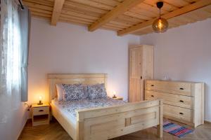 a bedroom with a wooden bed and a wooden dresser at Pepi Vendégház - Casa de oaspeți Pepi in Joseni