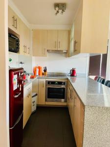 a kitchen with wooden cabinets and stainless steel appliances at Depto en Viña in Viña del Mar