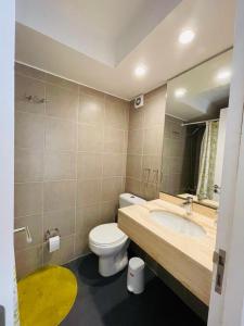 a bathroom with a toilet and a sink with a mirror at Depto en Viña in Viña del Mar