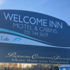 una señal para el motel y las cabañas de bienvenida de la posada en Welcome Inn, en Mattawa