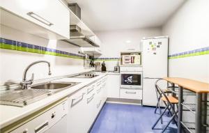 a kitchen with white appliances and a wooden table at Stunning Apartment In Oropesa Del Mar in Oropesa del Mar