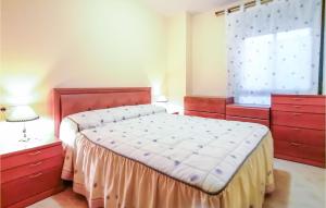 a bedroom with a bed with red dressers and a window at Stunning Apartment In Oropesa Del Mar in Oropesa del Mar +5 photos