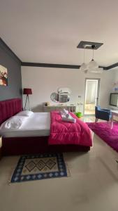 um quarto com uma cama grande e um cobertor vermelho em Guest's Apartament em Pogradec