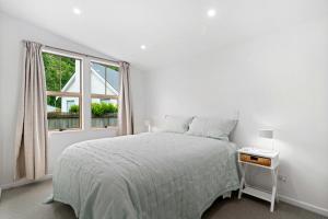 une chambre blanche avec un lit et une fenêtre dans l'établissement Gold Rush Cottage - Arrowtown Holiday Home, à Arrowtown