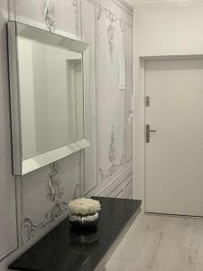 a room with a black table with a mirror and a door at Jurata Apartament Glamour in Jurata