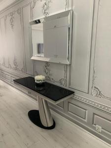 un tavolo nero in una stanza bianca con un armadietto di Jurata Apartament Glamour a Jurata