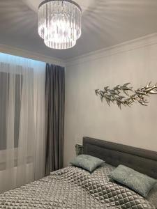 a bedroom with a bed and a chandelier at Jurata Apartament Glamour in Jurata