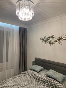sypialnia z łóżkiem i żyrandolem w obiekcie Jurata Apartament Glamour w Juracie