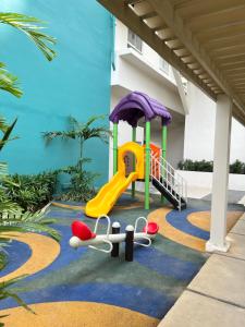 a playground with a slide and a slideintend at Lovely Studio Condominiums at Mesavirre Garden Residences Bacolod in Bacolod
