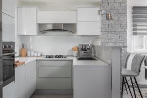 een witte keuken met witte kasten en apparaten bij Luxury Holiday Home Dioniz in Podgora
