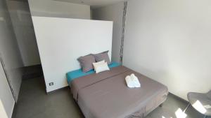 um quarto com uma cama com duas toalhas em VILLA ELA - Jolie villa avec piscine chauffée et jacuzzi em Les Abymes