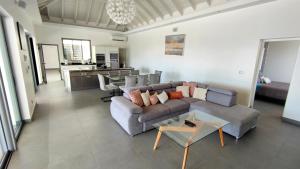 uma sala de estar com um sofá e uma mesa em VILLA ELA - Jolie villa avec piscine chauffée et jacuzzi em Les Abymes