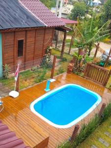 una piscina en una terraza junto a una casa en Chalés praia do Rosa SC piscina comp, en Imbituba