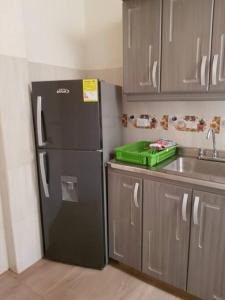 a kitchen with a black refrigerator and a sink at Casa Bethlen in Zapatoca