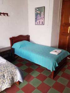 a room with two beds and a checkered floor at Casa Bethlen in Zapatoca