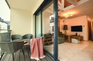 Televízia a/alebo spoločenská miestnosť v ubytovaní Apartament Pistacjowy