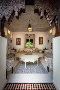 a living room with a table in the middle of a room at Riad les remparts de la kasbah in Marrakesh