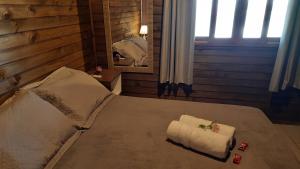 a bedroom with a bed with two towels on it at Chalés Mirante da Zimba in Imbituba