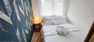 a bedroom with a bed with white sheets and pillows at Vikend kuća Planinski raj in Pale