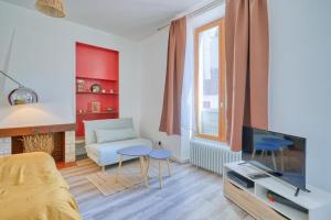 een woonkamer met een bed en een televisie bij studio cosy hypercentre proche Paris in Corbeil-Essonnes