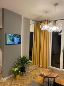 a living room with yellow curtains and a tv at Capital Towers RZESZOW, free parking, terrace in Rzeszów