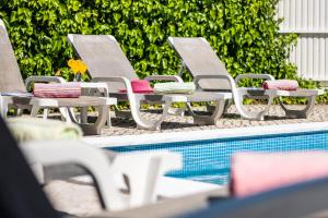 eine Gruppe von Liegestühlen neben einem Swimmingpool in der Unterkunft Villa Bermudas by Algarve Vacation in Albufeira