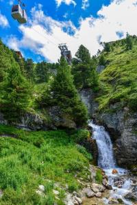 una góndola volando sobre una cascada en una montaña en ARC 2000 Appartement 2 pieces en Résidence 4 étoiles, en Arc 2000