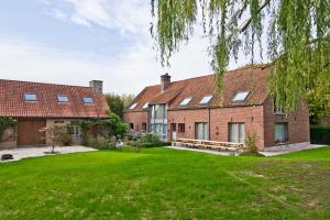 a large brick house with a green yard at Vakantiewoning L'Eau Tendre in Ellezelles, met wellness en buitenzwembad met overkapping in Ellezelles