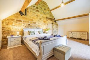 a bedroom with a large bed and a stone wall at Meadowsweet in Whitby