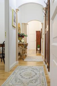 a hallway with white walls and an arched entry way with a rug at B&B CORSO VITTORIO in Venosa
