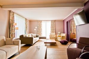 a living room with couches and chairs and a table at Vakantiewoning L'Eau Tendre in Ellezelles, met wellness, buitenzwembad en paardenstalling in Ellezelles