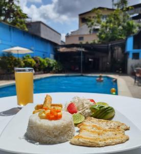 a plate of food on a table with a glass of beer at Hotel Virrey Pucallpa EIRL in Pucallpa