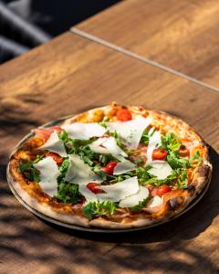 una pizza sobre una mesa de madera en Hotel DUM en Belgrado