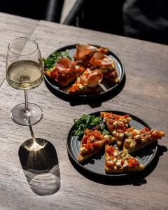 a table with two plates of food and a glass of wine at Hotel DUM in Belgrade