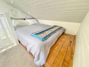 ein kleines Schlafzimmer mit einem Bett im Dachgeschoss in der Unterkunft Steps from Manly Beach in Sydney
