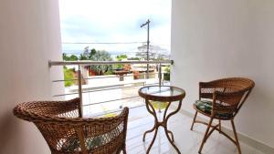 balcón con 2 sillas, mesa y ventana en Casa com 3 suítes perto da Praia e do Centro de Porto Seguro, en Porto Seguro