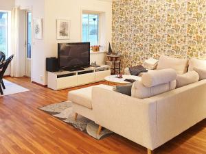 ein Wohnzimmer mit einem weißen Sofa und einem TV in der Unterkunft Holiday home VäTö in Harg