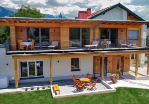 a house with a deck with a table and chairs at Seespitz 37 - Ferienwohnungen Eisendle in Seeboden