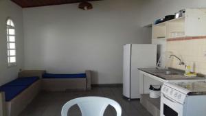 サンセバスチャンにあるChalés 1 e 2 dormitórios - Juquehyのキッチン(白い冷蔵庫、白い椅子付)