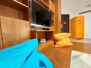 sala de estar con TV de pantalla plana y sofá en Sweet Dreams Suites Cosy Studio Piata Romana en Bucarest