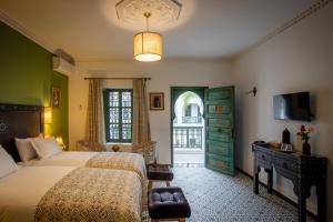 Postel nebo postele na pokoji v ubytování Riad les remparts de la kasbah