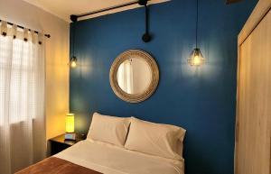 Dormitorio azul con cama y espejo en Casa Azul, en Medellín