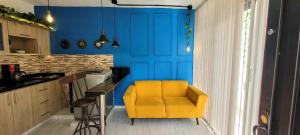 una silla amarilla en una cocina con una pared azul en Casa Azul, en Medellín