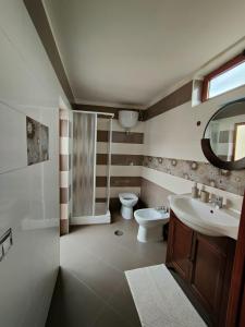 uma casa de banho com um lavatório, um WC e um espelho. em La Maison di Titty em Torre Annunziata