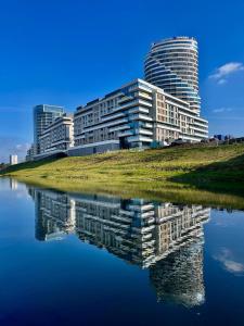 a building with its reflection in a body of water at Capital Towers RZESZOW, free parking, terrace in Rzeszów