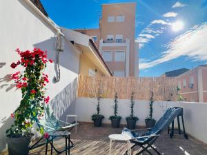 a balcony with chairs and flowers on a building at Soho Boho Apartments - with sunny rooftop terrace and fiber optic internet in Alicante