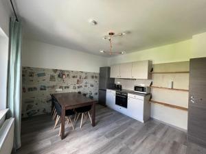 a kitchen with a wooden table and white cabinets at Haus 15 Apartments in Bielefeld