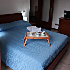 a bed with a tray with four tea pots on it at Ampio appartamento a 5 minuti da Rho-fiera Milano in Cornaredo